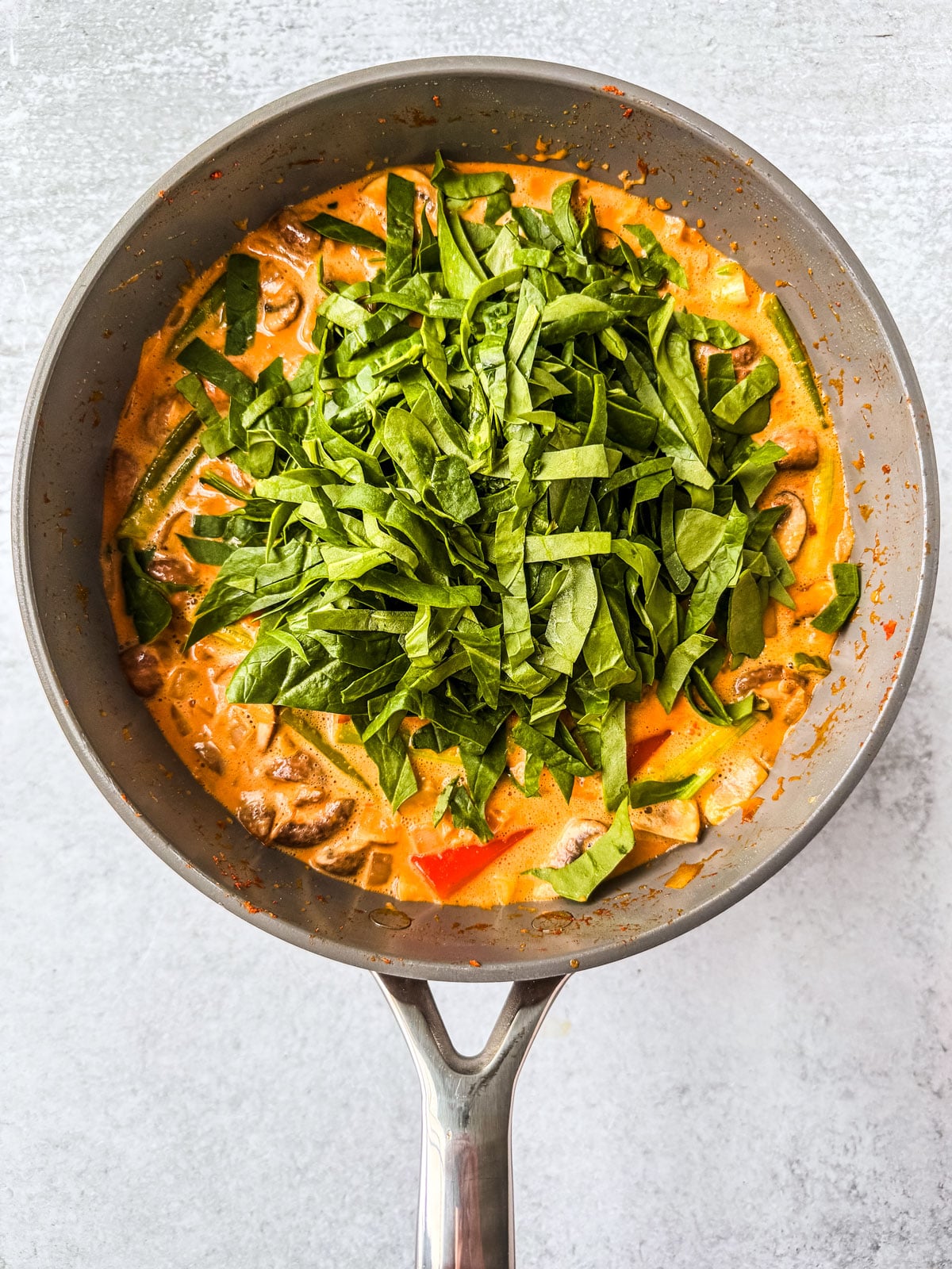Ribboned spinach added to the curry.