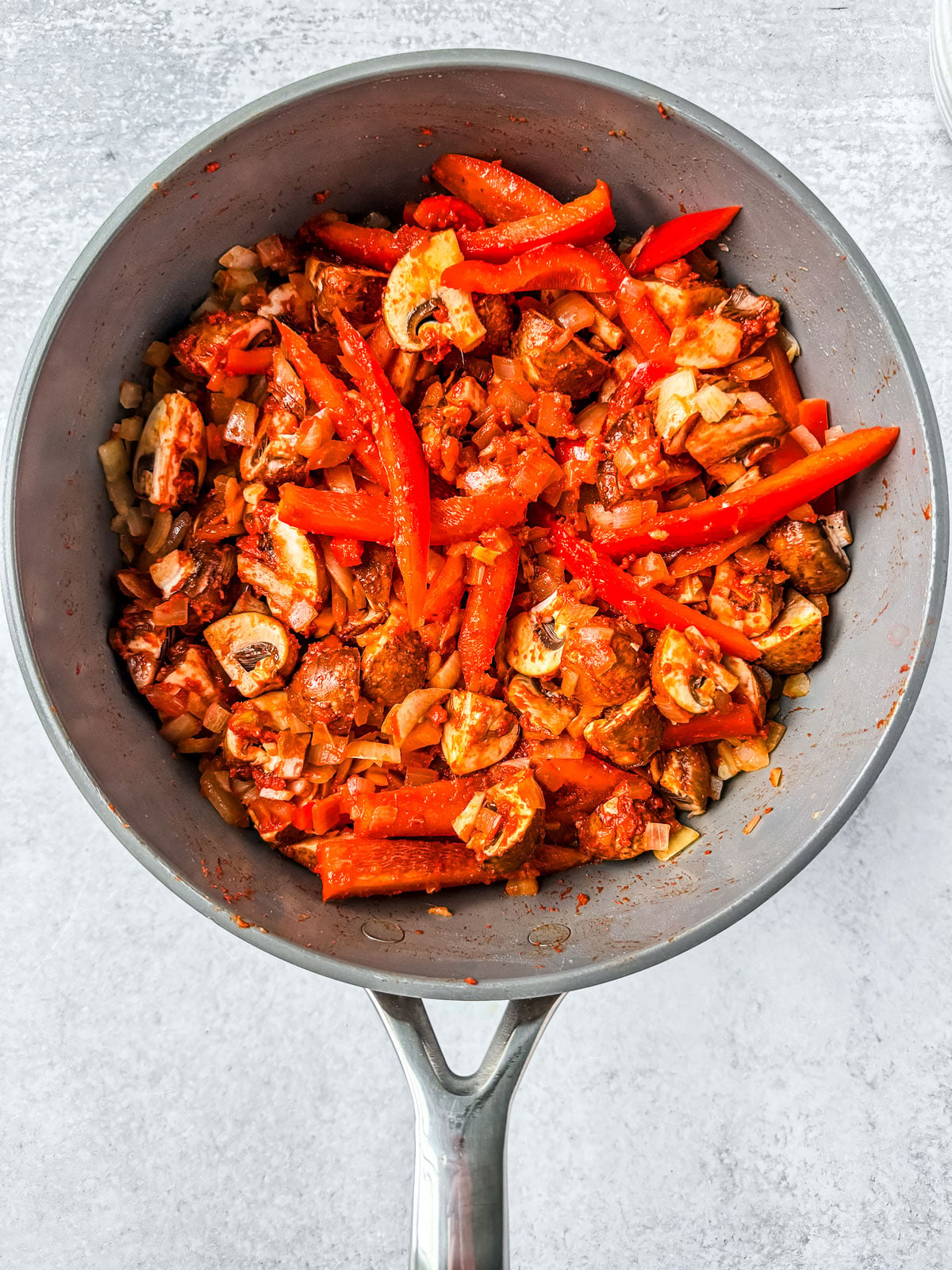 Red curry paste stirred into the vegetables to coat.