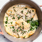 Skillet with flounder fillets in creamy lemon caper sauce.