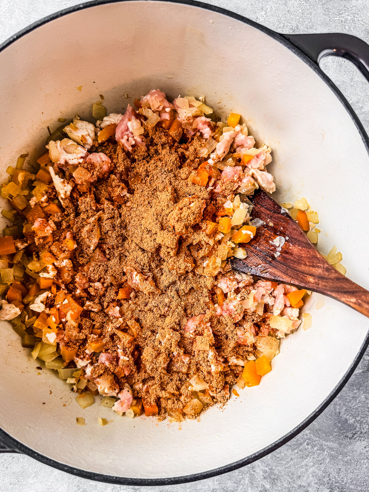 Onions, peppers, and ground turkey in large pot covered in seasoning.