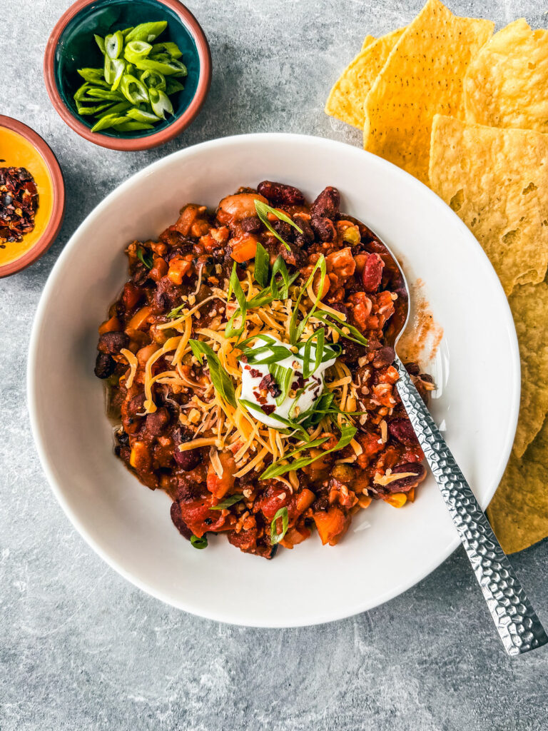 Bowl of ground turkey chili with chips on the side.