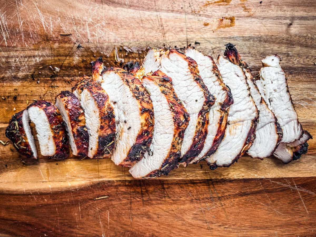 Air fryer turkey breast sliced on a cutting board.