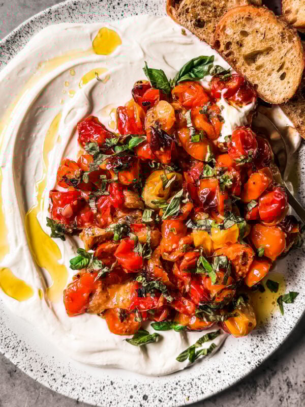 Serving platter with whipped ricotta topped with roasted tomatoes.