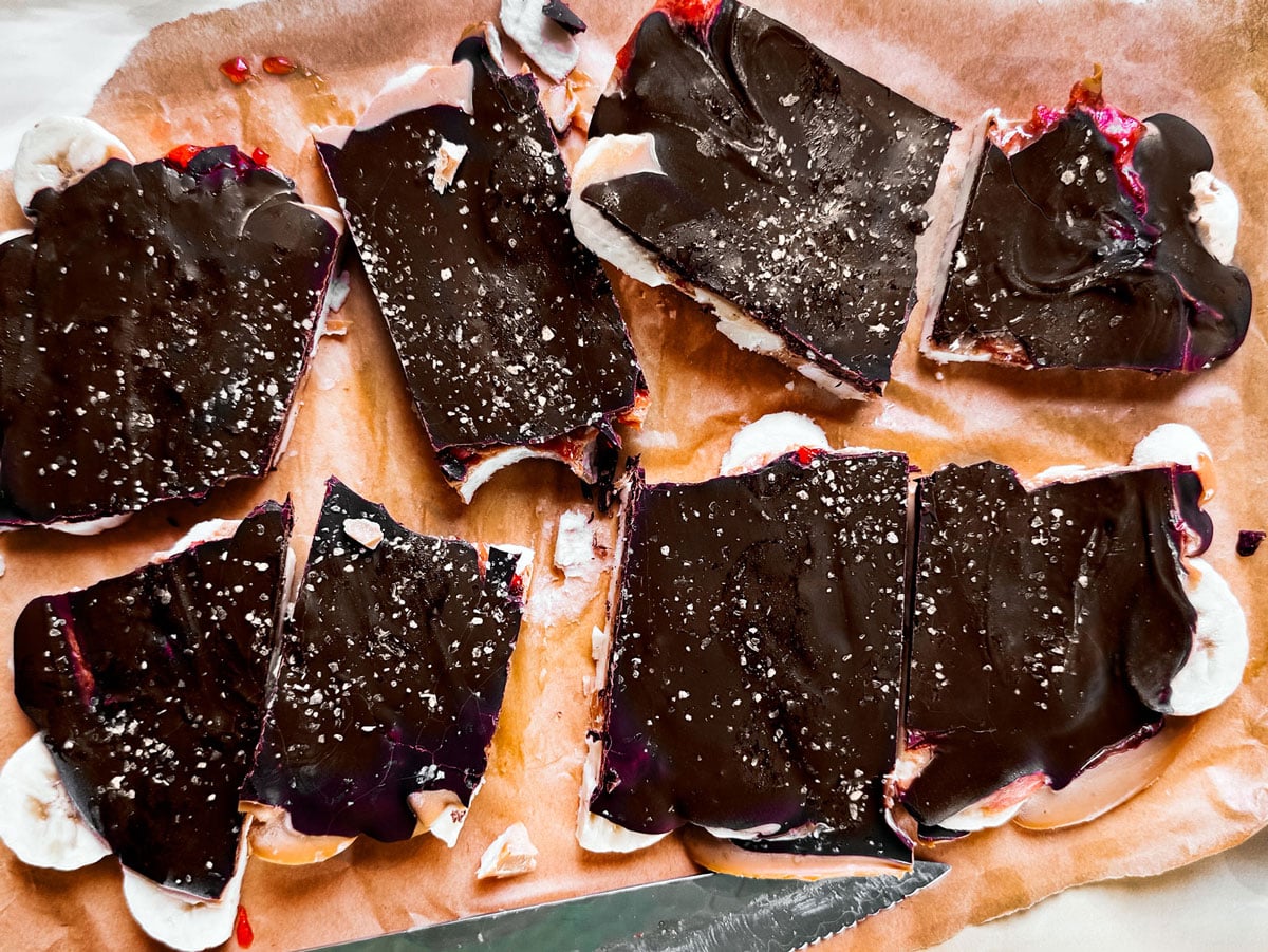 Pieces of chocolate banana bark broken over parchment.