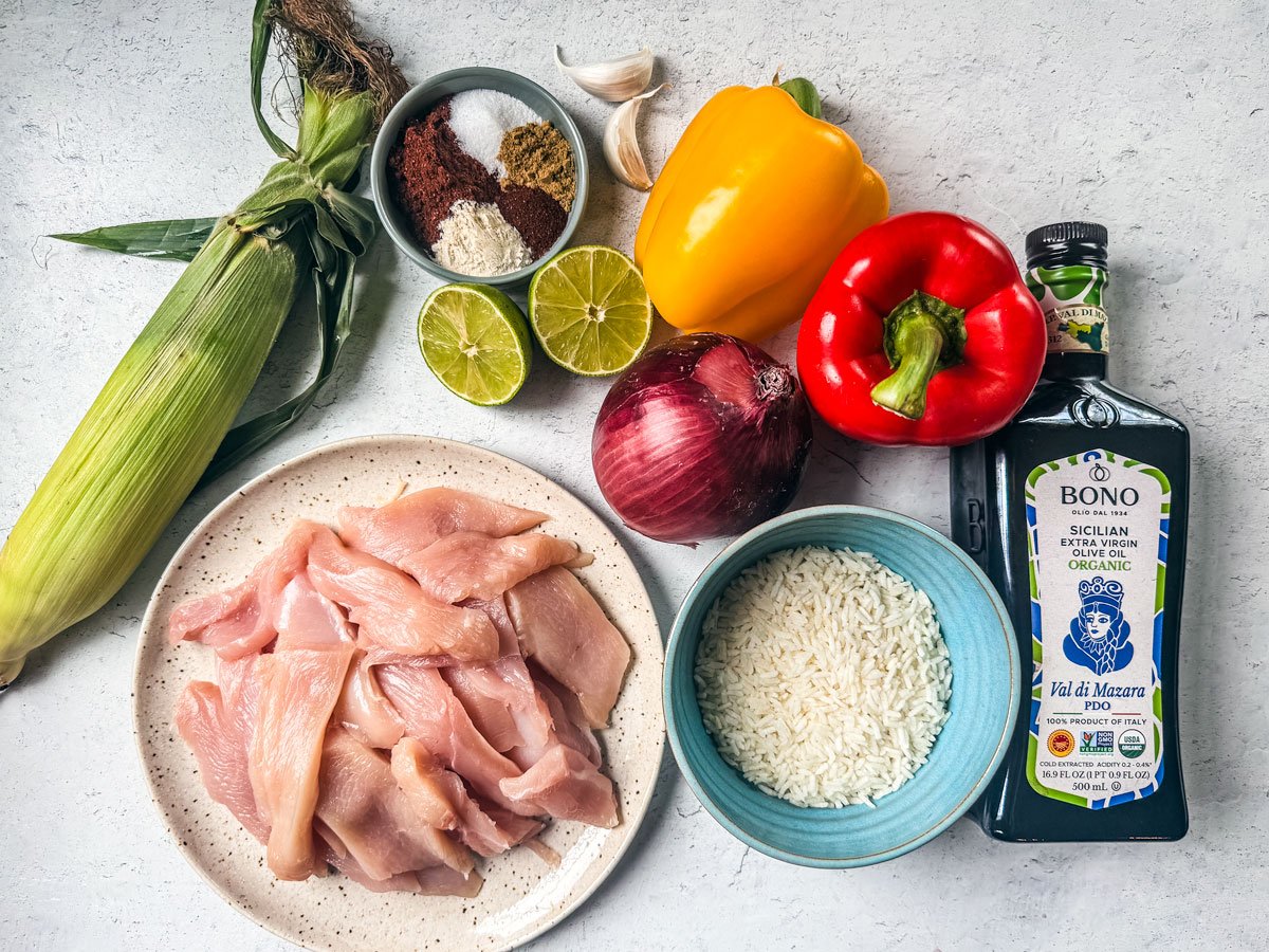 Ingredients for a chicken fajita bowl on a white background.