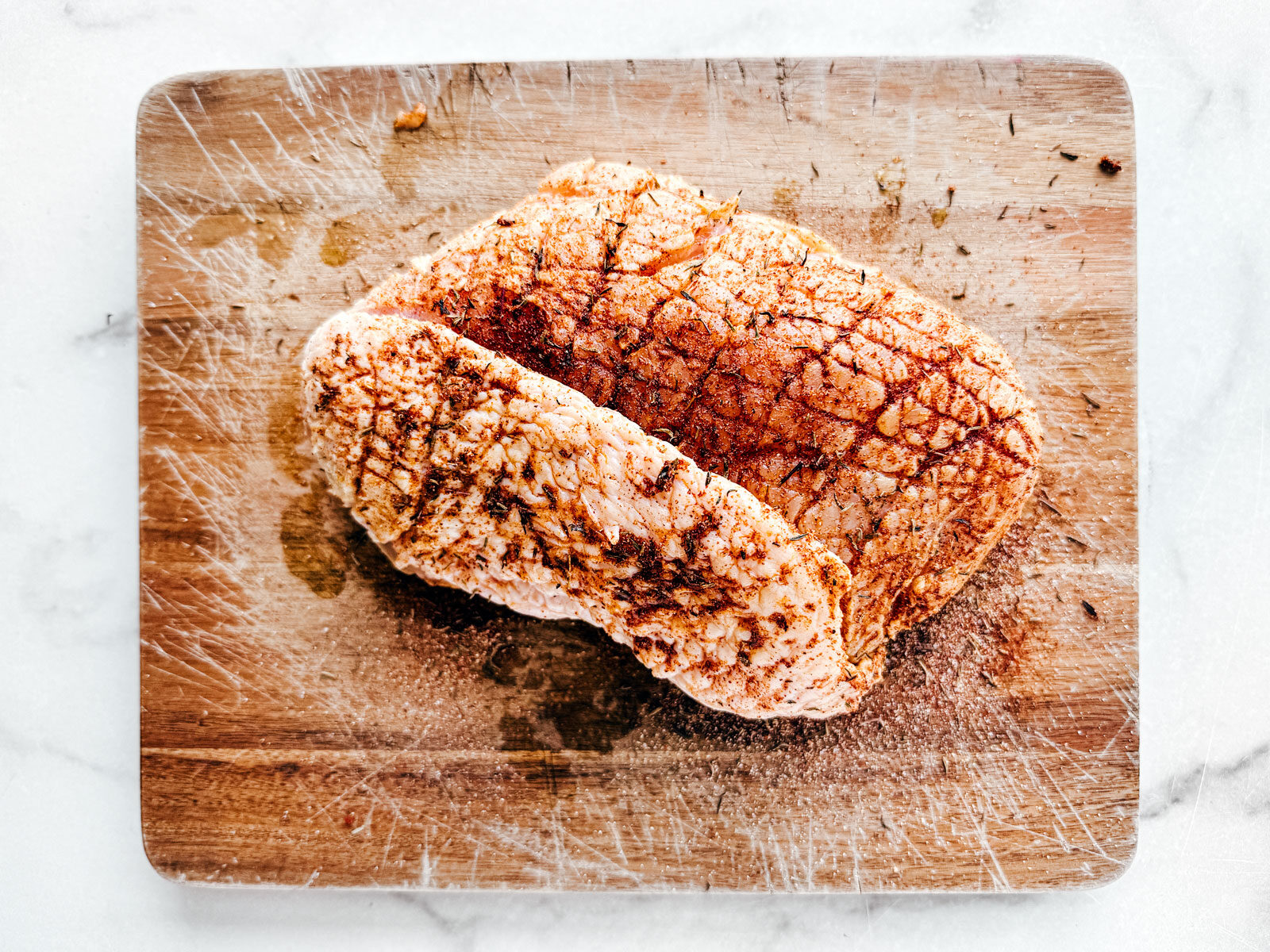 Seasoned turkey breast on a cutting board.