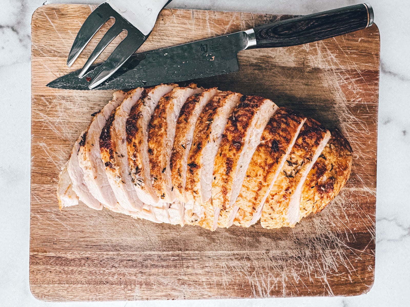 Turkey breast sliced on a cutting board.