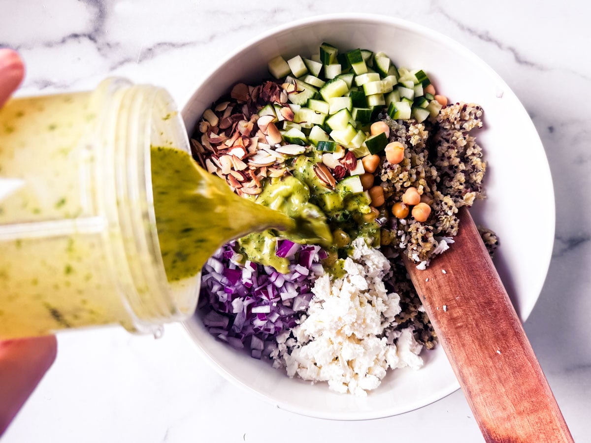 Vinaigrette is being poured over the salad.