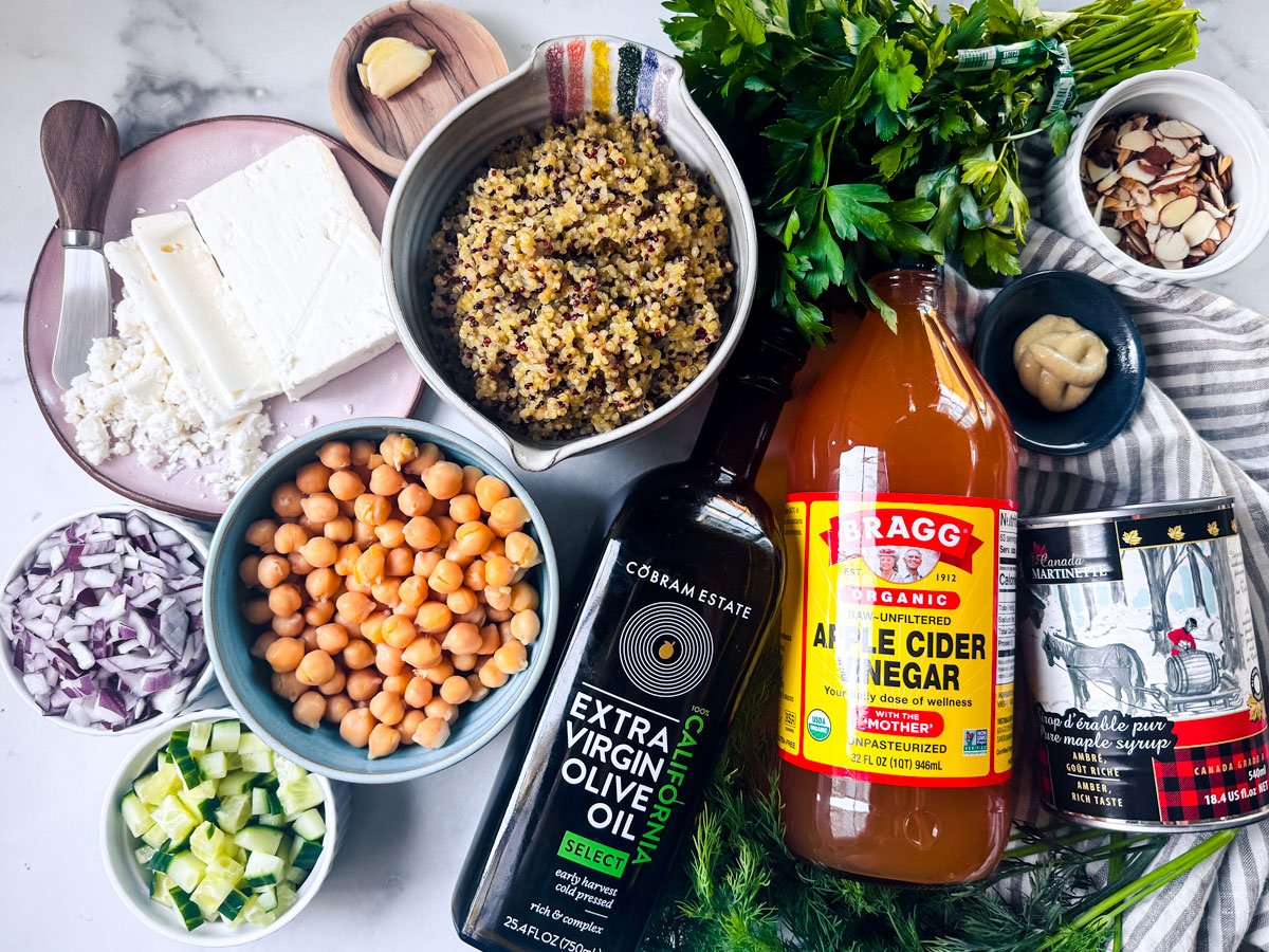 Ingredients for quinoa chickpea salad on a white marble countertop.