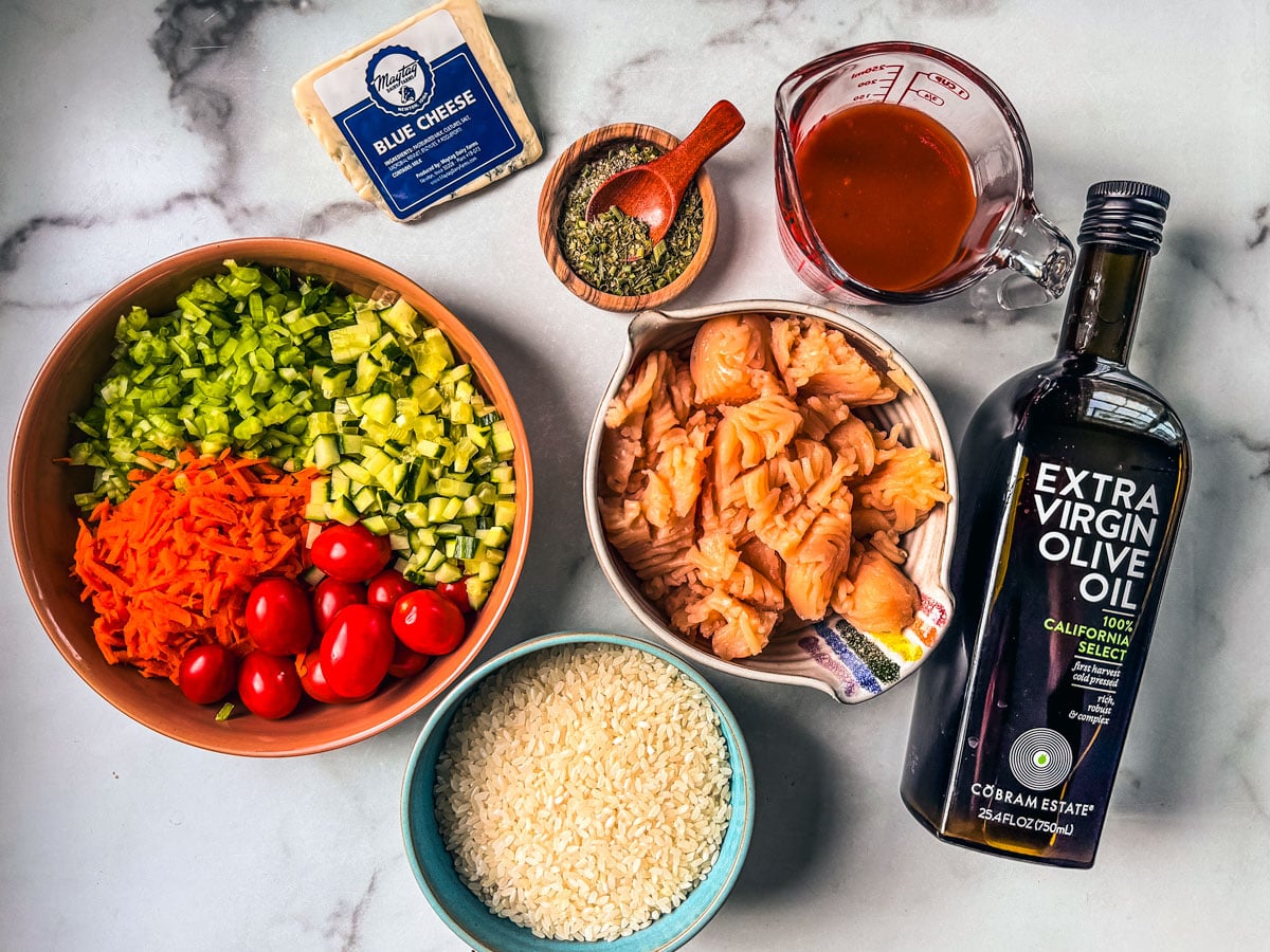 Ingredients for Buffalo Chicken Bowls are spread out on a marble countertop.