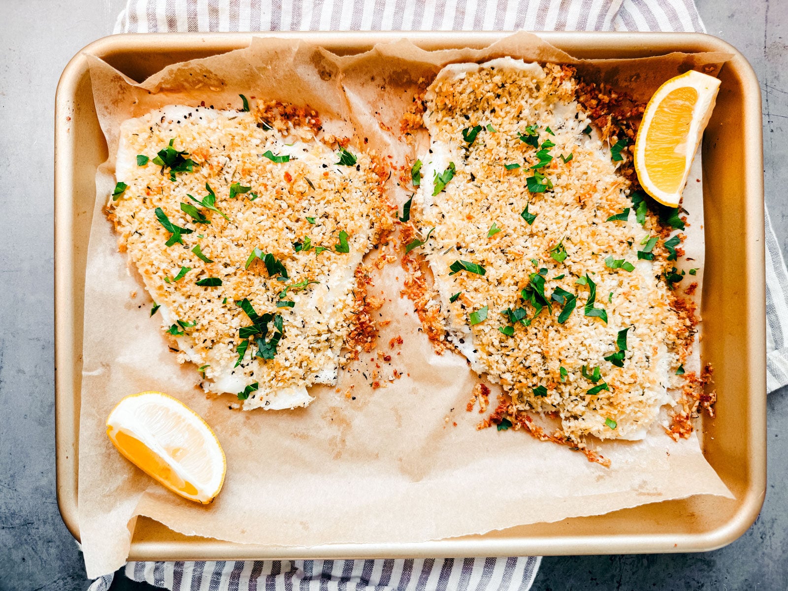 Cooked golden crisp flounder au gratin on baking sheet.
