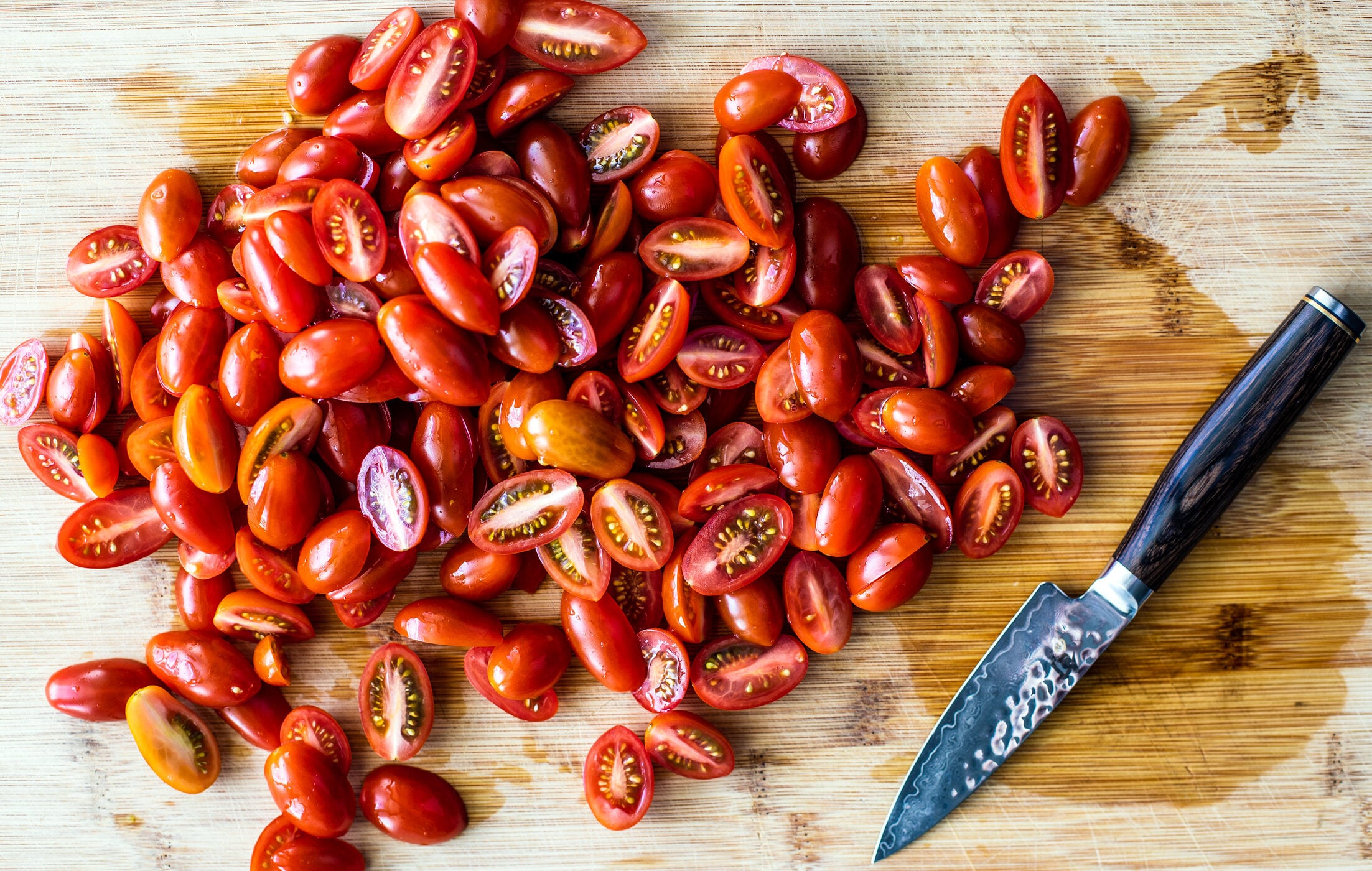 Bright cut up tomatoes on a cutting board.