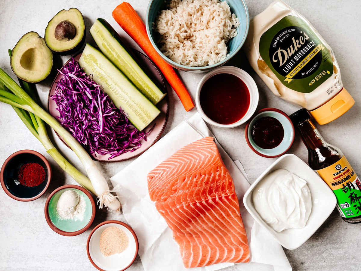 Ingredients for bang bang salmon bowls on a white background.
