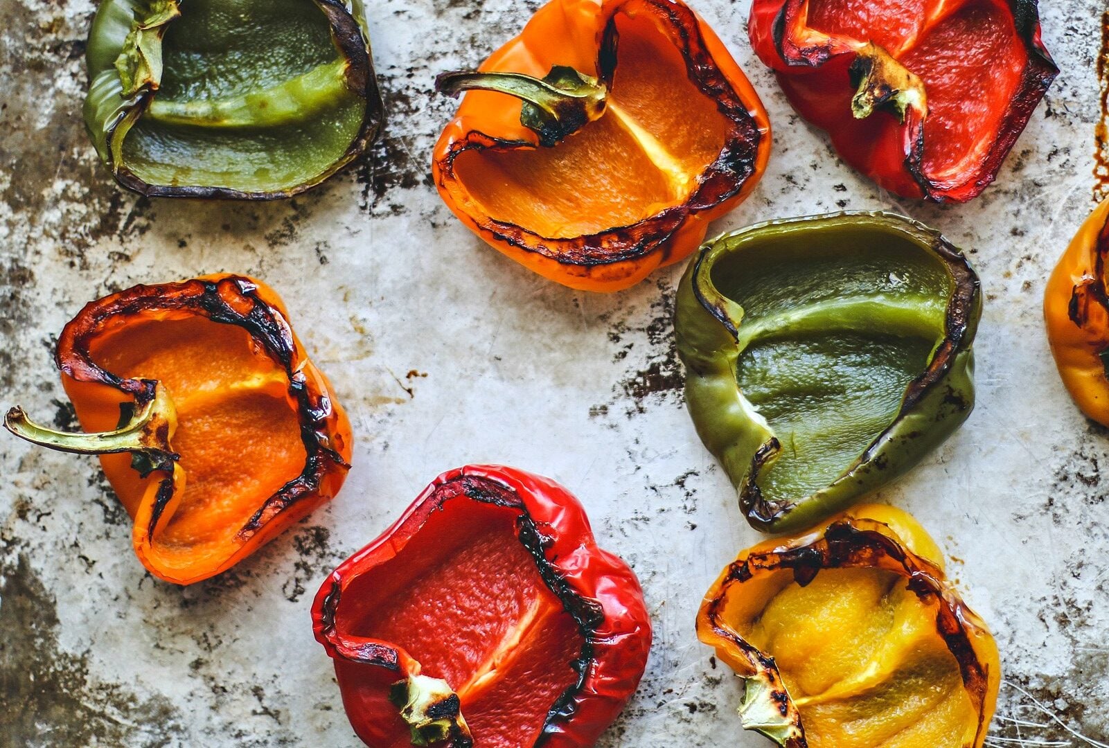 Empty roasted peppers on a baking sheet.