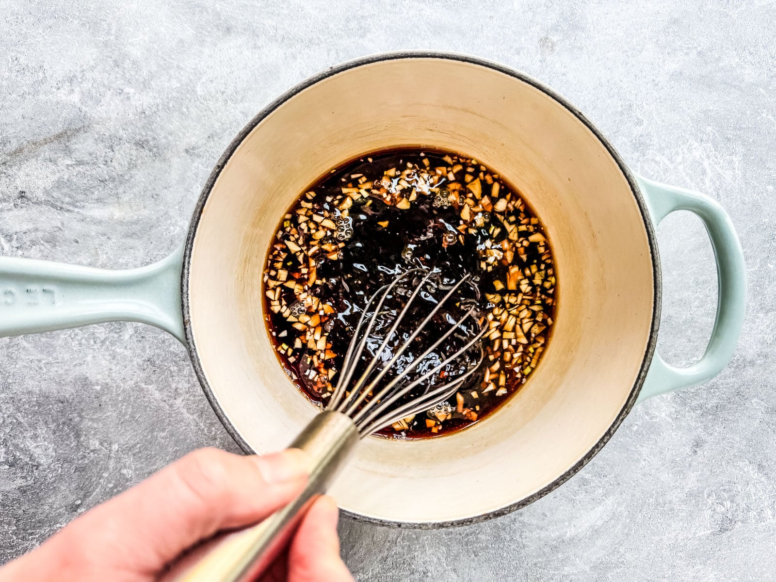 Ingredients for teriyaki sauce being whisked in a saucepan.