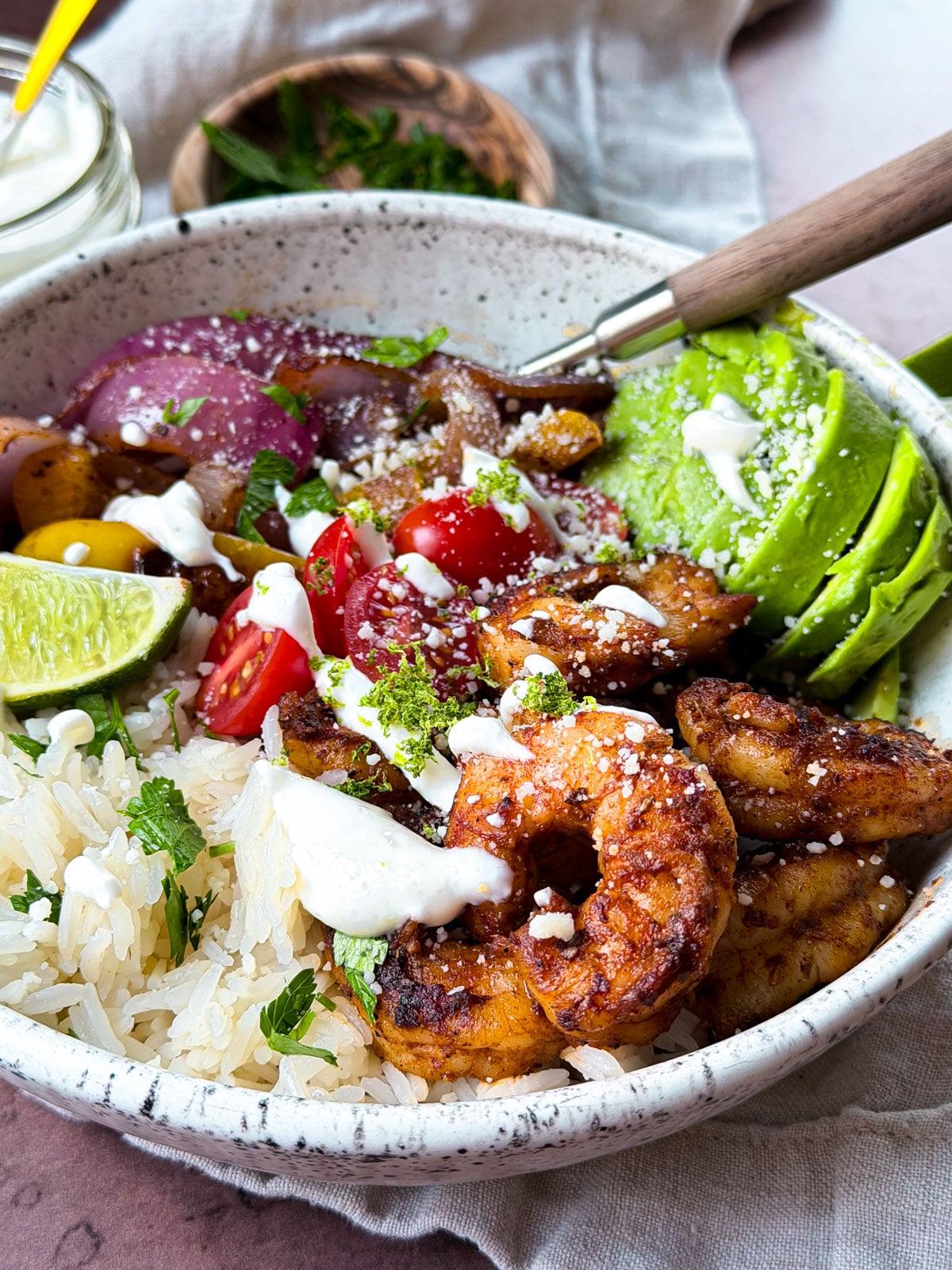 Bowl of seasoned shrimp with rice and veggies.