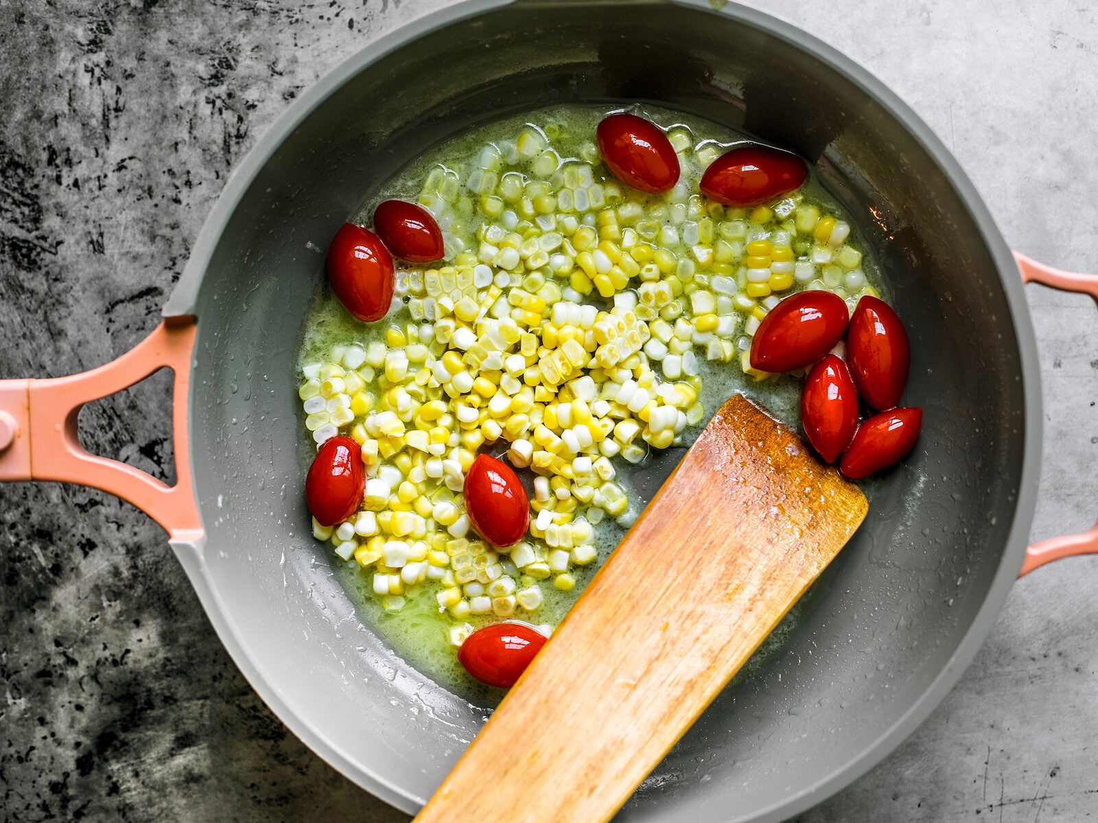 Corn and tomatoes in a pan with butter.