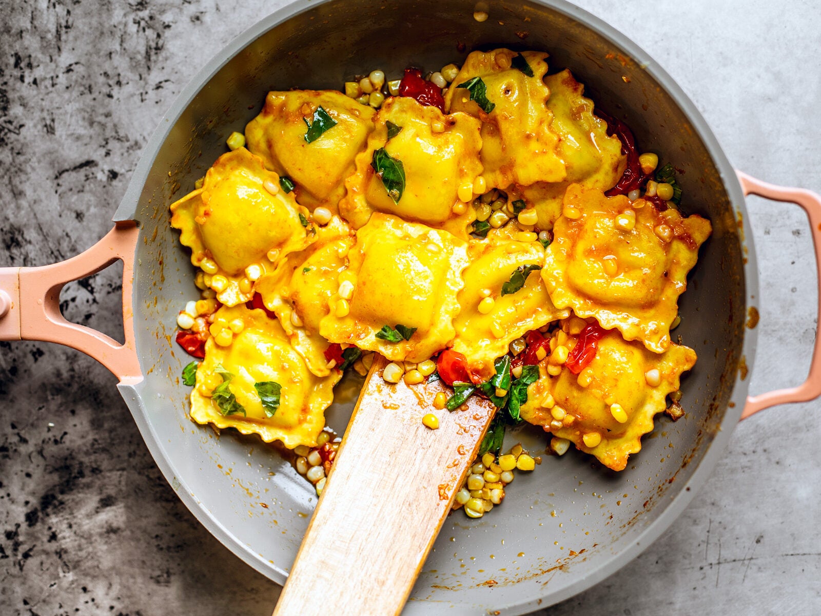 ravioli in lemon butter sauce tossed in a pan.