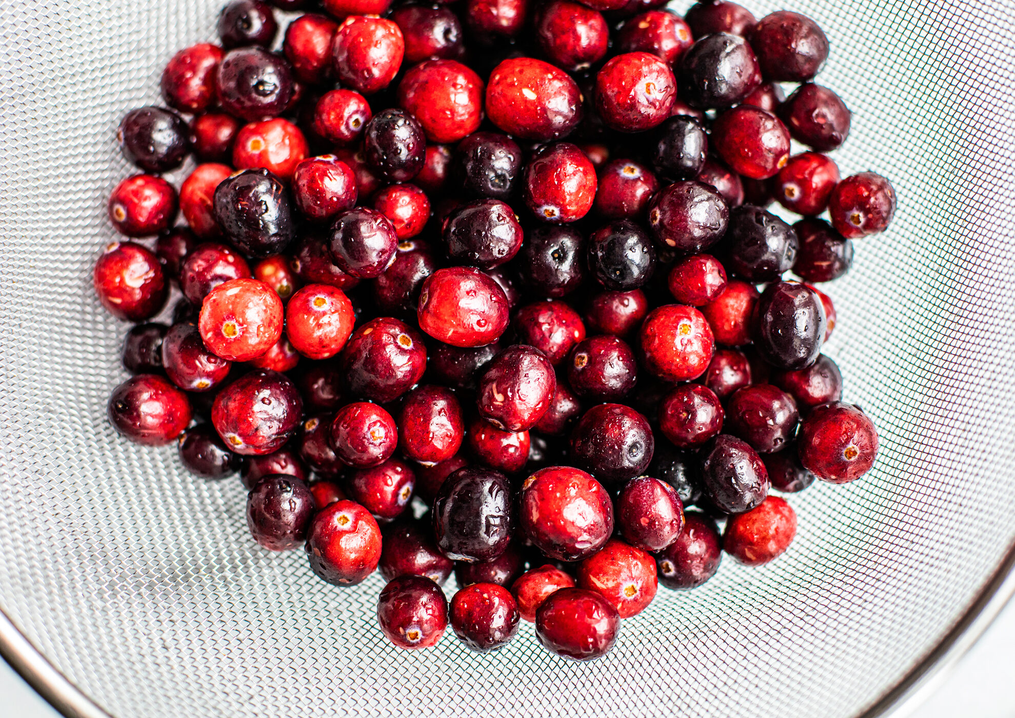Close up of fresh cranberries in a colander.
