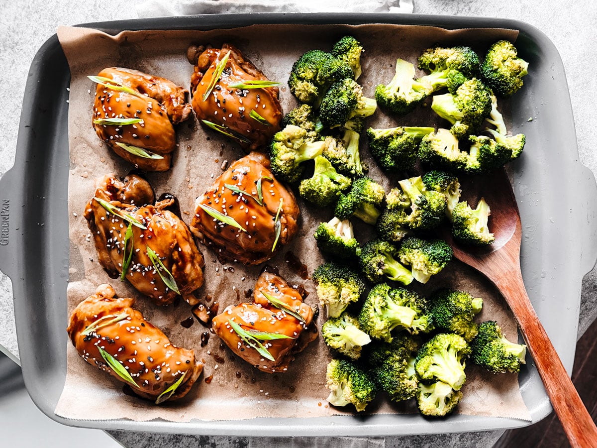 sheet pan with teriyaki chicken thighs and broccoli florets.